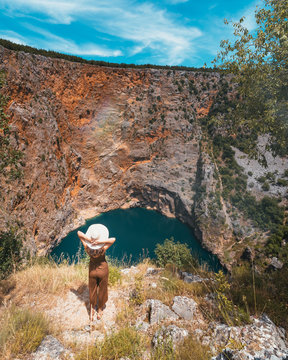 A young woman looking at the Red Lake in Imotski, Croatia