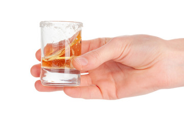 Man's hand holding a glass with  tequila