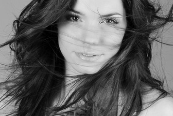 Portrait d'une jeune femme brune souriante en studio