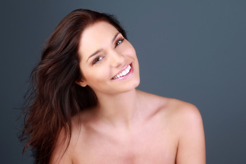 Naklejka premium Portrait d'une jeune femme brune souriante en studio