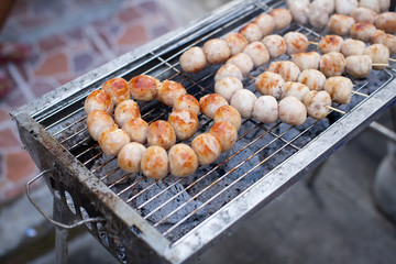 Grilled Isaan sausage on a charcoal stove