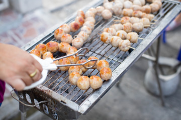 Grilled Isaan sausage on a charcoal stove