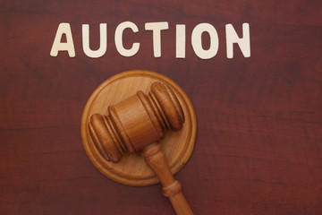 Auction gavel on wooden table with word auction. Auction business concept.