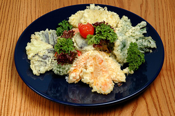 Mini kebab of oysters and marzipan on a blue plate, on a wooden background. Restaurant dish, appetizer with vegetables