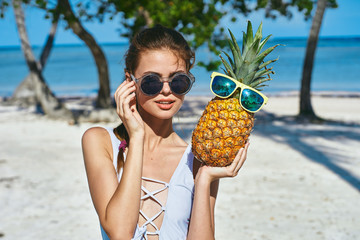 woman with pineapple on the beach