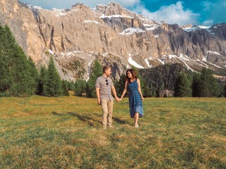 Naklejka premium Brunette girl hugging a boy, walking on the lawns in the mountains.