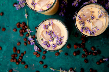 Summer drink iced coffee with lavender in glass and coffee beans on green background. Good Morning...