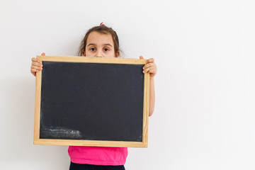 Little girl holding black board on white background