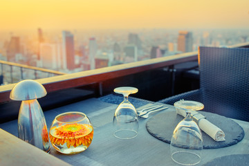 Table setting on roof top restaurant with megapolis view, Bangkok Thailand.