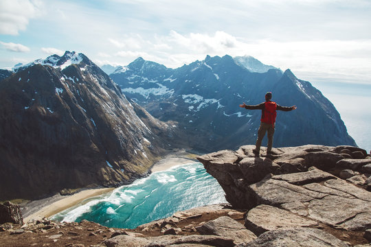 Man stand on cliff edge alone enjoying aerial view backpacking lifestyle travel adventure outdoor vacations