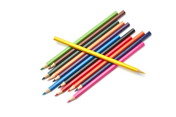 Yellow pencil alone lies on a stack of other colored pencils lying on an isolated white background