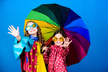 Walk under umbrella. Kids girls happy friends under umbrella. Bright umbrella. Happy childhood. It is easier to be happy together. Be rainbow in someones cloud. Rainy weather with proper garments