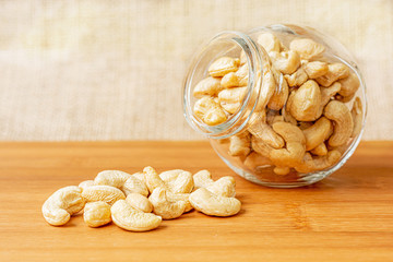 Healthy cashew nuts in a glass and on a wooden desk. Food photography. Healthy fresh cashew nuts. Minimalist photography. The Latin name of cashew is Anacardium occidentale.