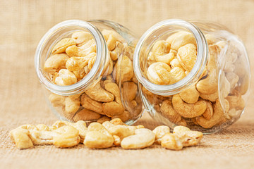 Healthy cashew nuts in a glass and on a jute background. Food photography. Healthy fresh cashew nuts. Minimalist photography. The Latin name of cashew is Anacardium occidentale.