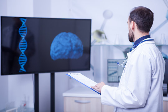 Doctor in his cabinet looking at a braind and trying to put a diagnosis
