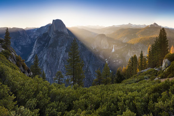 Fototapeta premium Half Dome and Yosemite Valley in Yosemite National Park during colorful sunrise with trees and rocks. California, USA Sunny day in the most popular viewpoint in Yosemite Beautiful landscape background