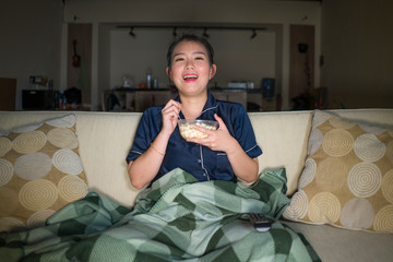 young beautiful happy and cheerful Asian Korean woman watching TV comedy movie or hilarious show...