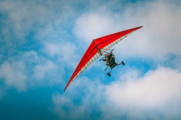 Ultralight aircraft flight in the blue air with clowds