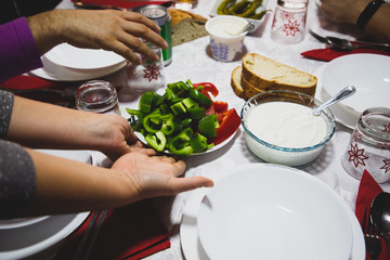 Woman hands serving dishes on the table with red and green pepper