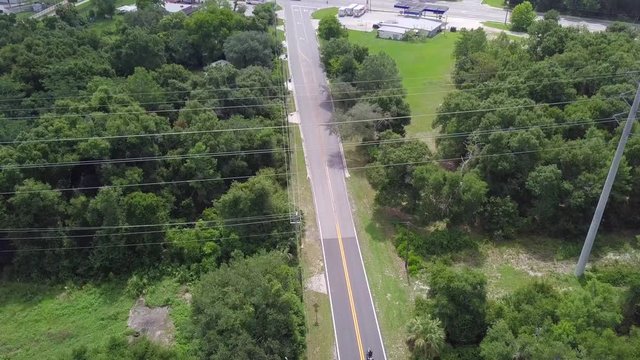 A guy on a motorcycle approaches an intersection in Florida but then decides he needs gas.
