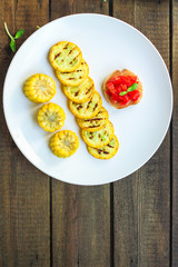 grilled zucchini and bruschetta with tomato (snack or snack salad). top food background. copy space