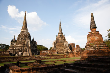 Fototapeta premium Distant view of the Ayutthaya ruined temple in Thailand with the blue sky as background