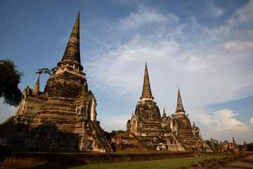 Fototapeta premium Distant view of the Ayutthaya ruined temple in Thailand with the blue sky as background