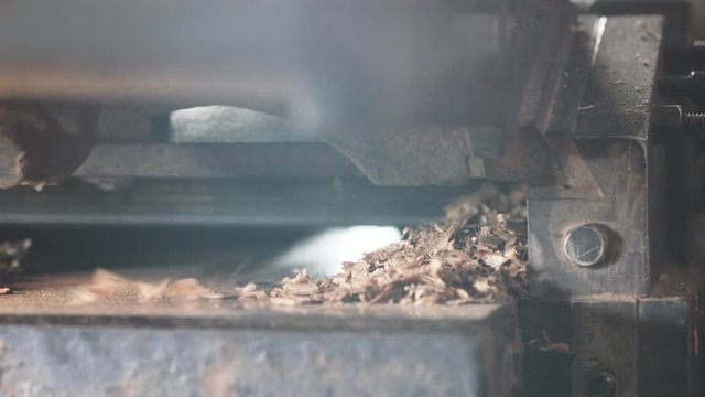 Close up footage of a machine which makes wooden shavings in a working carpentry factory