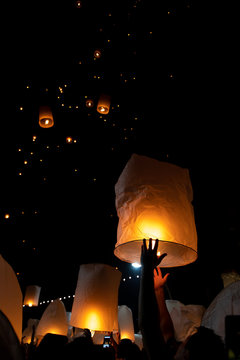 Unrecognizable Man Releasing Paper Lantern During Loi Krathong And Yi Peng Festival In Chian Mai