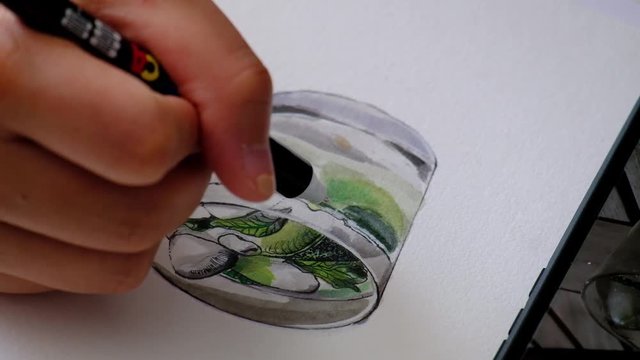 Artistic hand painting a mojito glass, close up
