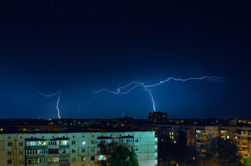 Naklejka na ściany i meble Thunderstorm with lightning and thunder over the night city