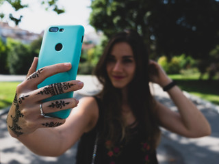 Girl taking selfie with smartphone blurred