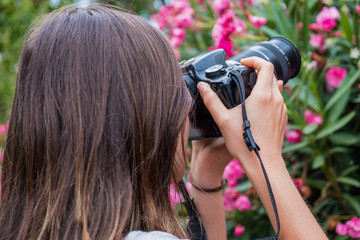 Girl taking pictures of flowers with DSLR camera