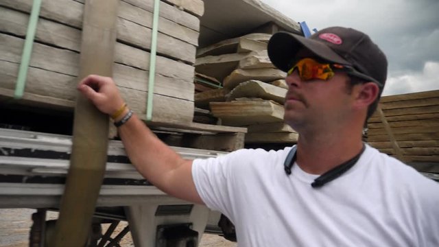 Trucker checks load of stone on tractor trailer