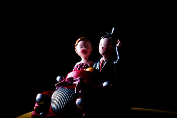 Ceramic toy car with married couple low key shot