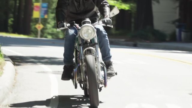 Motorcyclist With Leather Jacket Riding on a Wooded Road