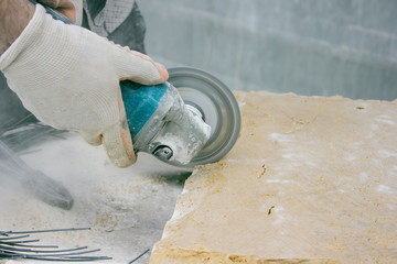 Worker cutting stone block by cutter machine.