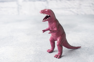 Dinosaur on a gray background. Plastic rubber toy. Selective focus.