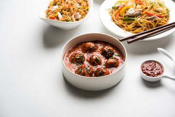 Assorted Indo chinese food in group includes non vegetarian or chicken Schezwan/Szechuan hakka noodles, fried rice, manchurian, egg american chop suey, soup with spoon and chop sticks, selective focus