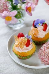 Cupcake decorated with buttercream, fruits and flowers