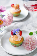 Cupcake decorated with buttercream, fruits and flowers