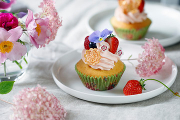 Cupcake decorated with buttercream, fruits and flowers