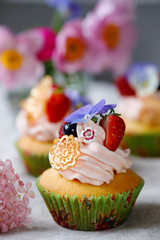 Cupcake decorated with buttercream, fruits and flowers