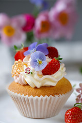 Cupcake decorated with buttercream, fruits and flowers