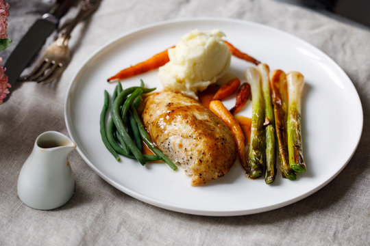 Roast dinner with chicken, baby leeks, carrots, green beans and potato mash