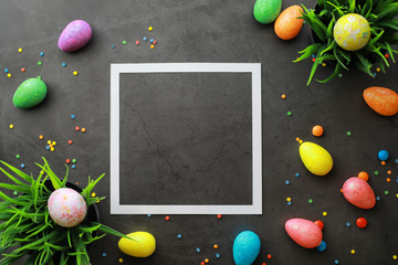 Easter background on black stone. Multicolored eggs and sweets.