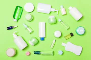 Group of plastic bodycare bottle Flat lay composition with cosmetic products on green background empty space for you design. Set of White Cosmetic containers, top view with copy space