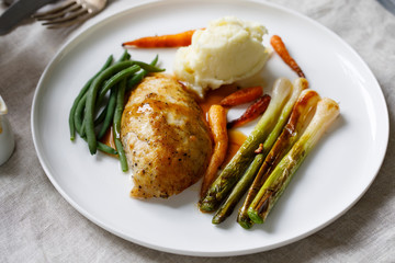 Roast dinner with chicken, baby leeks, carrots, green beans and potato mash