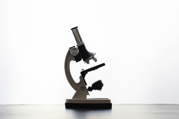 Research laboratory. Test tubes and microscope on the table on a white background.