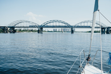 Nose yacht on the river in front of the bridge